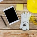 Architect engineer workplace standard construction safety equipment on gloves yellow helmet and