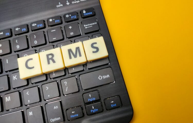 Black keyboard and toys word with the word CRMS on yellow background.