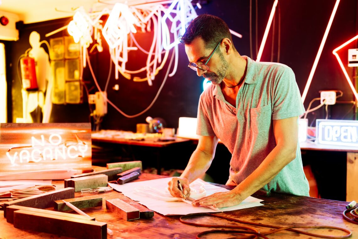 Focused man preparing design on paper with pencil