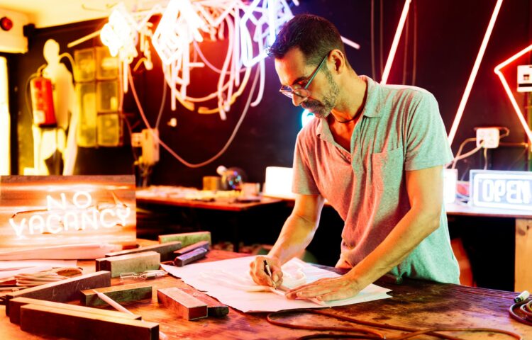 Focused man preparing design on paper with pencil