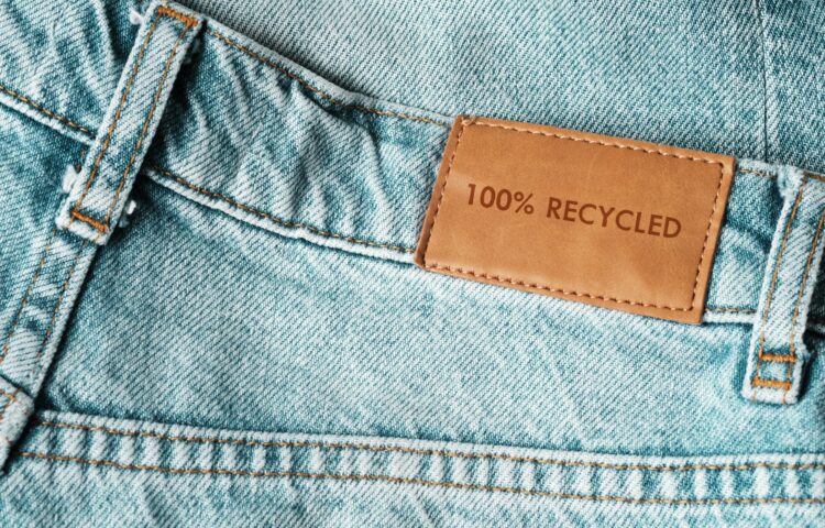 Jeans labeled 100% recycled. Sustainable fashion, conscious consumption.