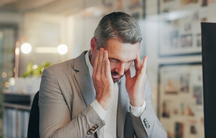 Stress, headache and mature man in office with computer, night work and frustrated with time manage