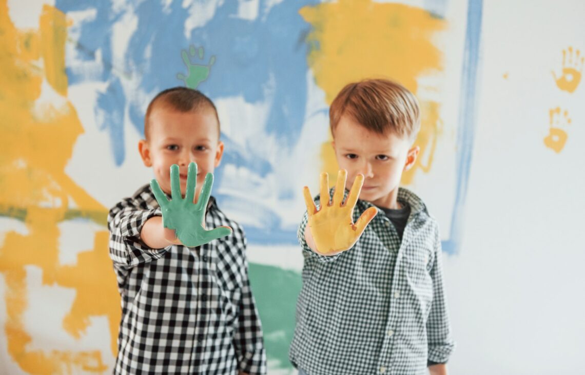 Two boys painting walls in the domestic room