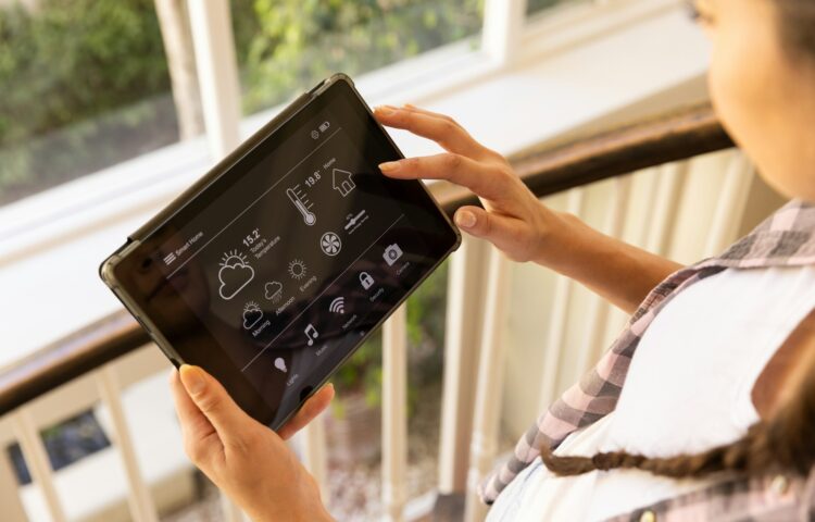 Using tablet, woman controlling smart home system with various settings