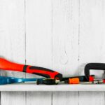 Working tools on wooden shelf.