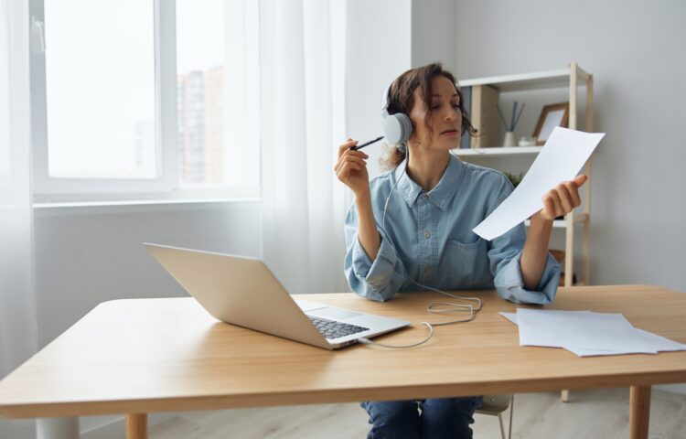Concentrated self-confident adorable curly businesswoman leader talking with colleagues at online