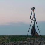Camera set up on a tripod in an open field