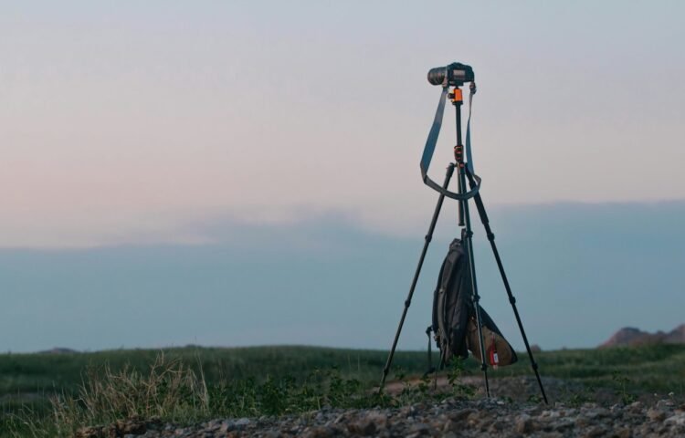 Camera set up on a tripod in an open field