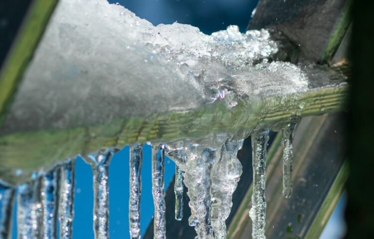 Icicles hanging from a roof gutter in freezing weather