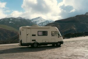 Camper van parked on a roadside with a snowy mountain backdrop