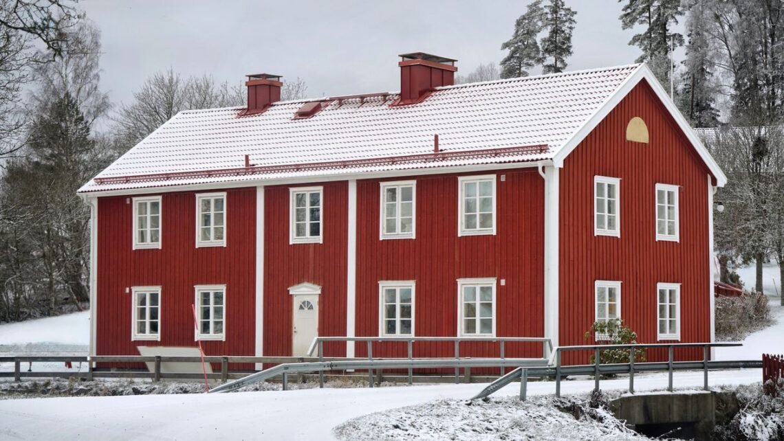 Red wooden house in winter snow