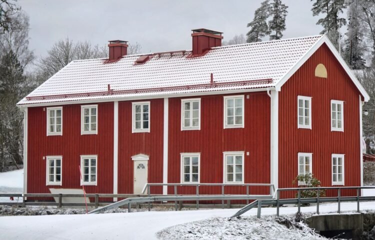 Red wooden house in winter snow