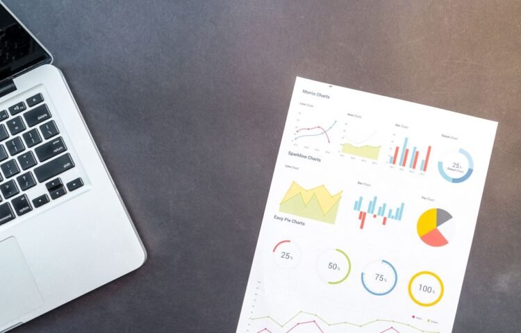 Modern desk setup with a laptop and analytical charts